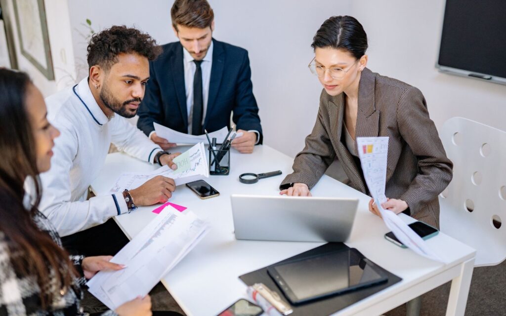 Business team reviewing records together at a laptop